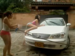 Cute little girls fooling around while washing a car