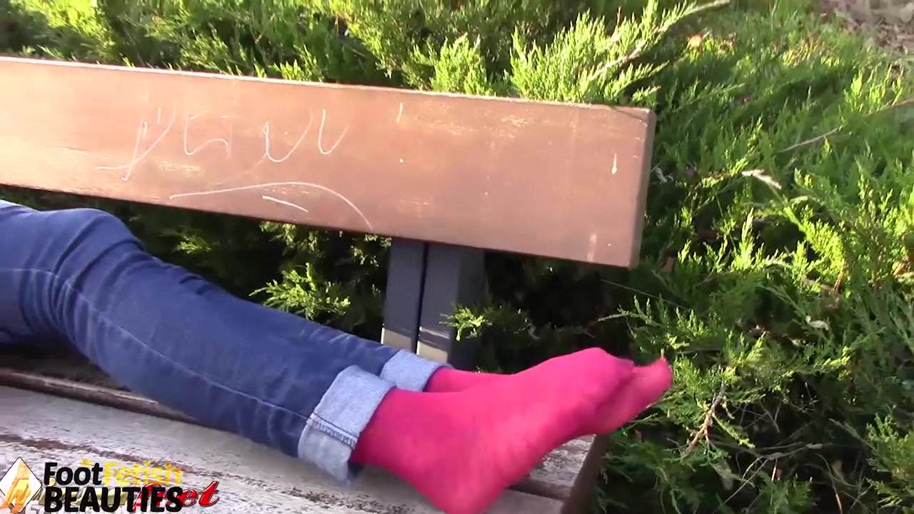 Barefoot brunette takes off nylons, shows feet in a park