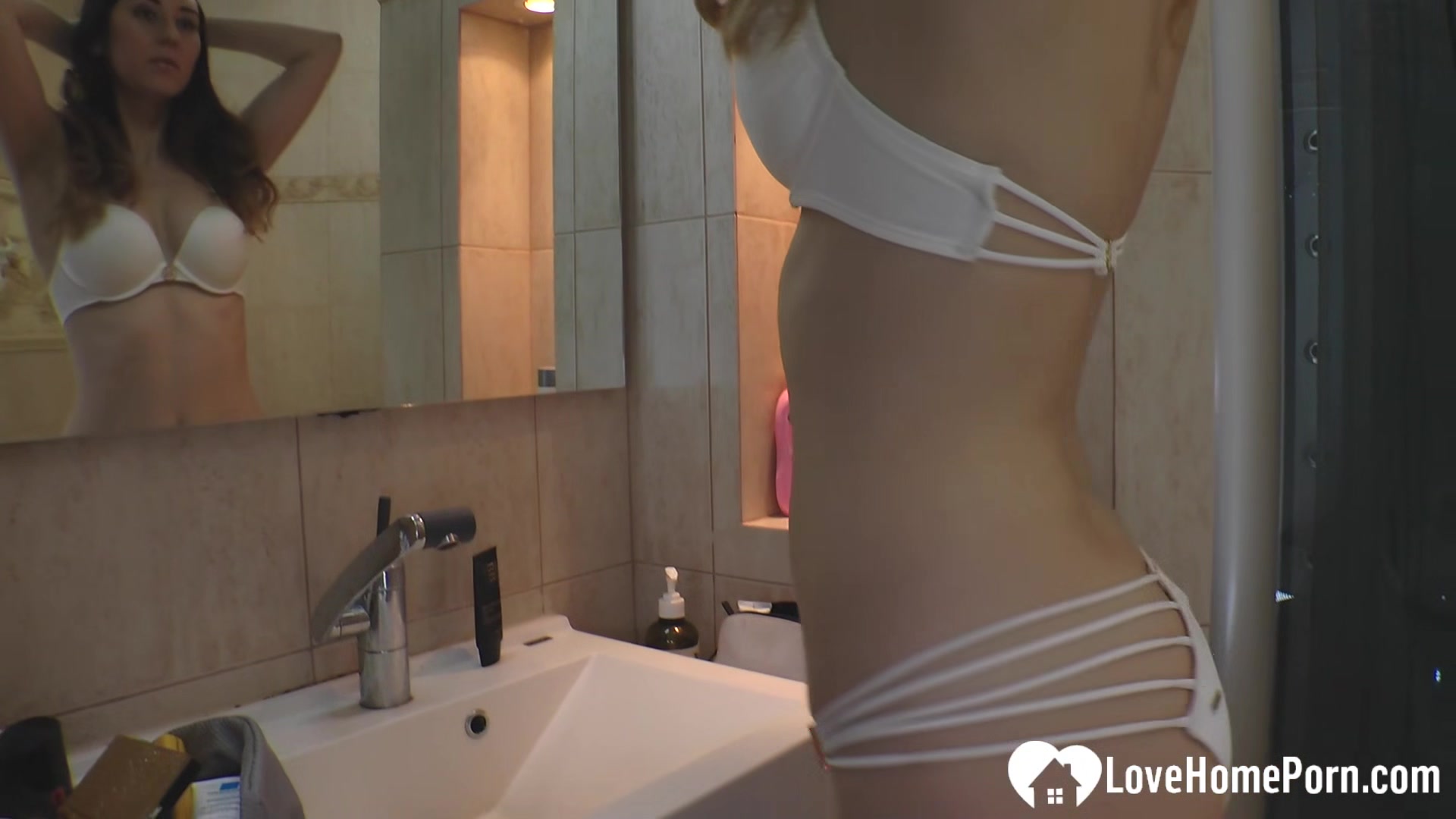 Brunette girlfriend trying high heels in the bathroom