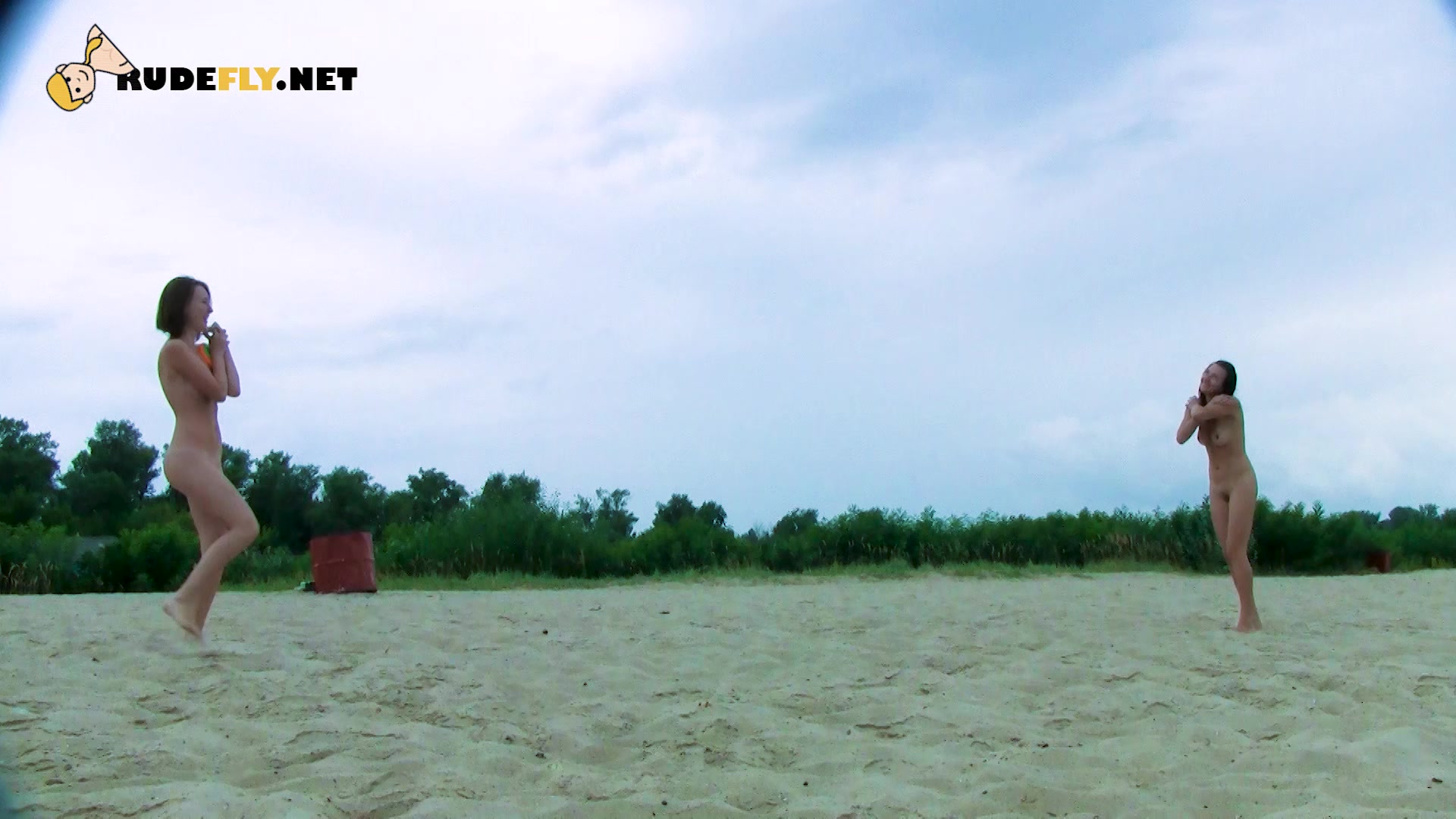 Nude beach girl is looking into the distance as her small tits and ass