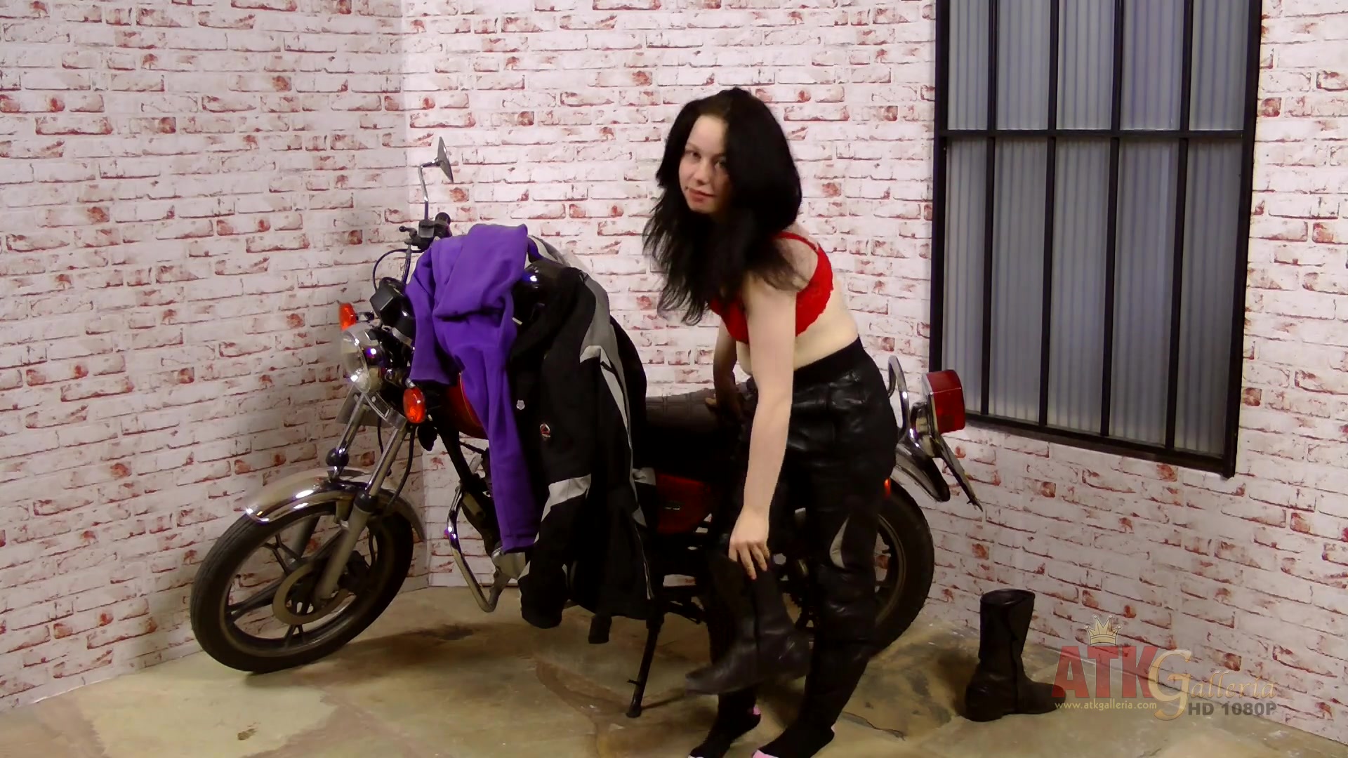 Lizzie does an extensive strip-tease by her big motorcycle