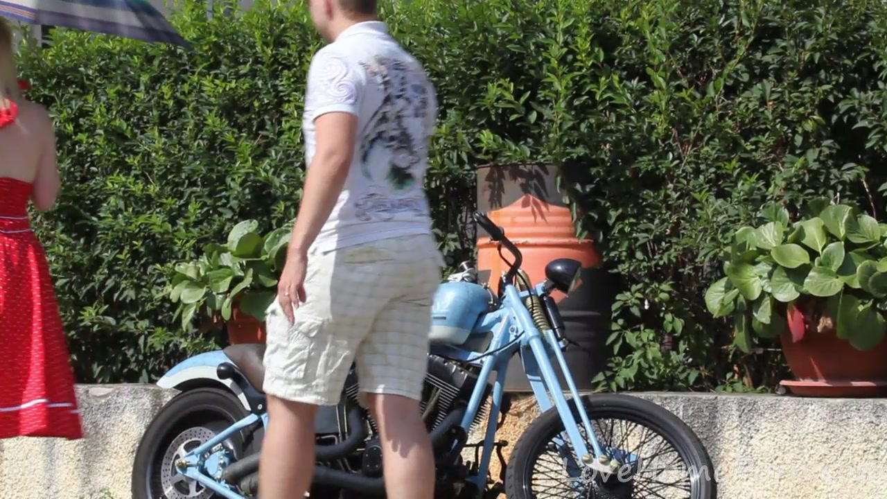 Cute blonde enjoys posing next to a bike