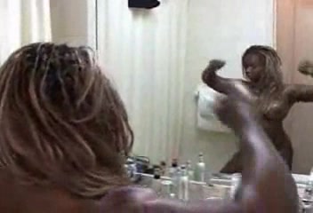 Black bodybuilder slut flexes muscles in front of the mirror