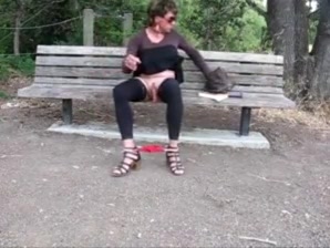 Lovely crossdresser jerks it on a park bench
