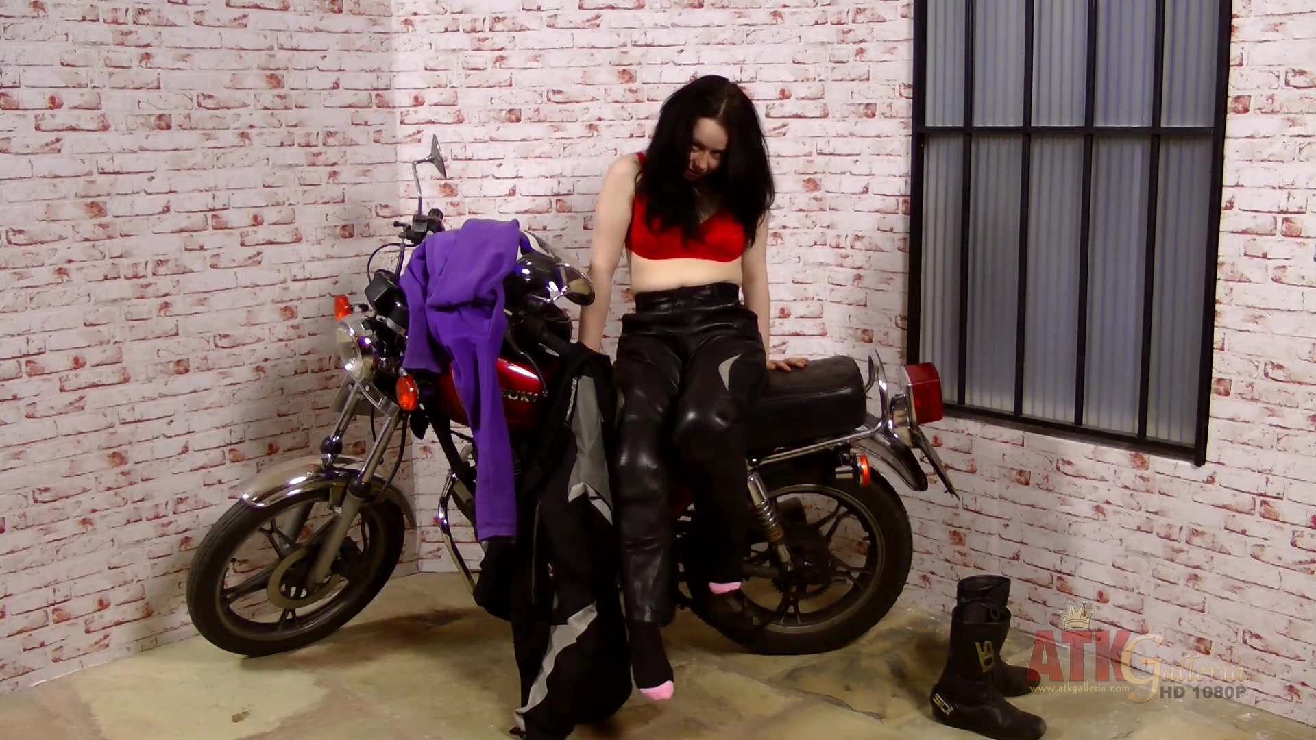 Lizzie does an extensive strip-tease by her big motorcycle