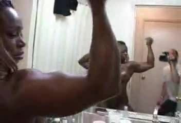 Black bodybuilder slut flexes muscles in front of the mirror