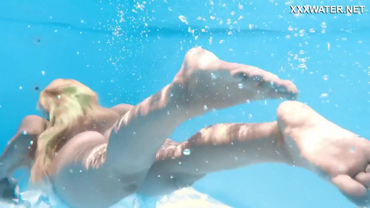Her Body Cutting Through The Shimmering Water Of The Pool
