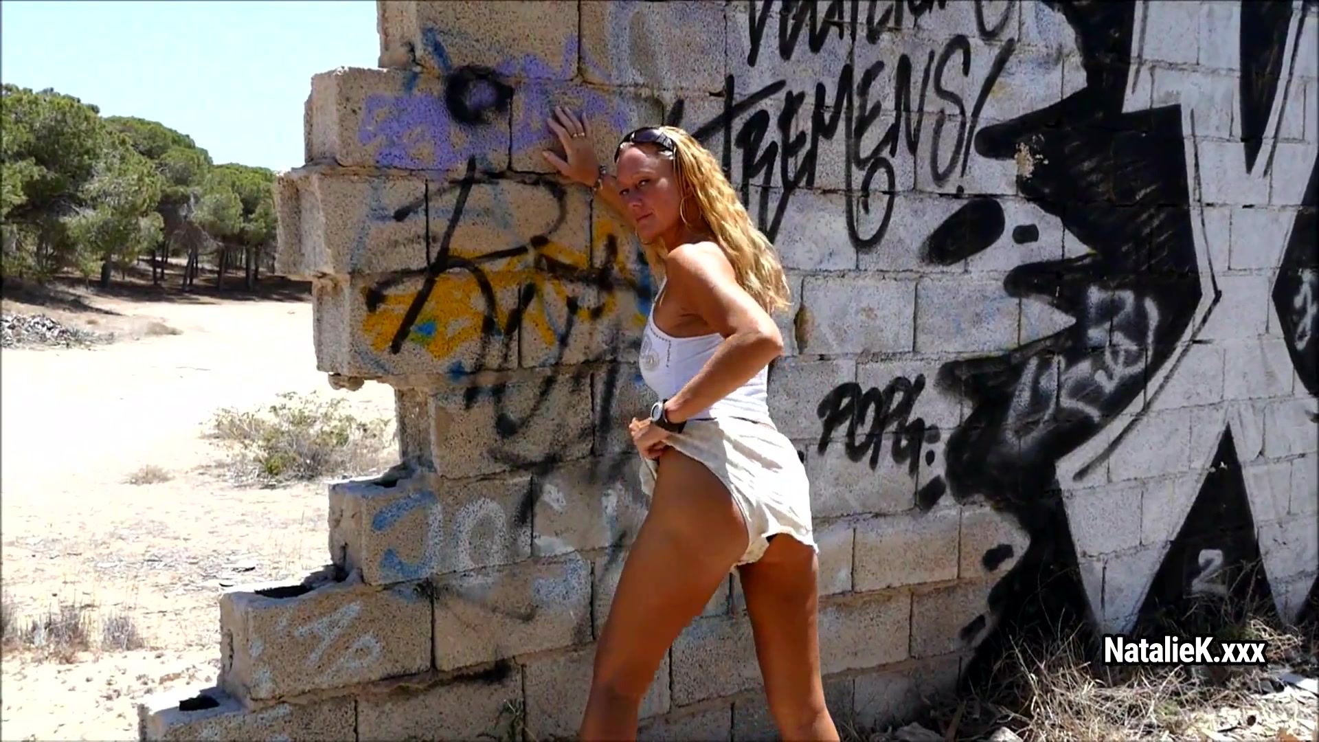 Strict Natalie K fingers her wet pussy against the white wall