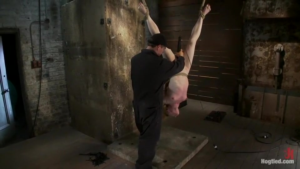 Redhead suspended by ankles with rope, face fuckedFlogged until her skin is bright pink.