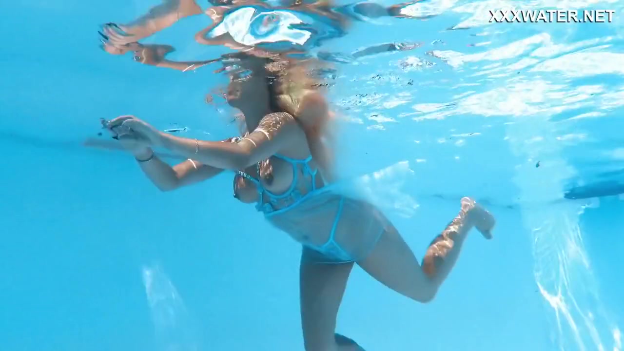 Her Body Cutting Through The Shimmering Water Of The Pool