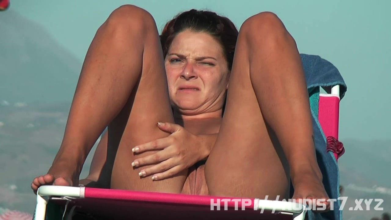 Stripped breasty honey widens legs at the nudist beach
