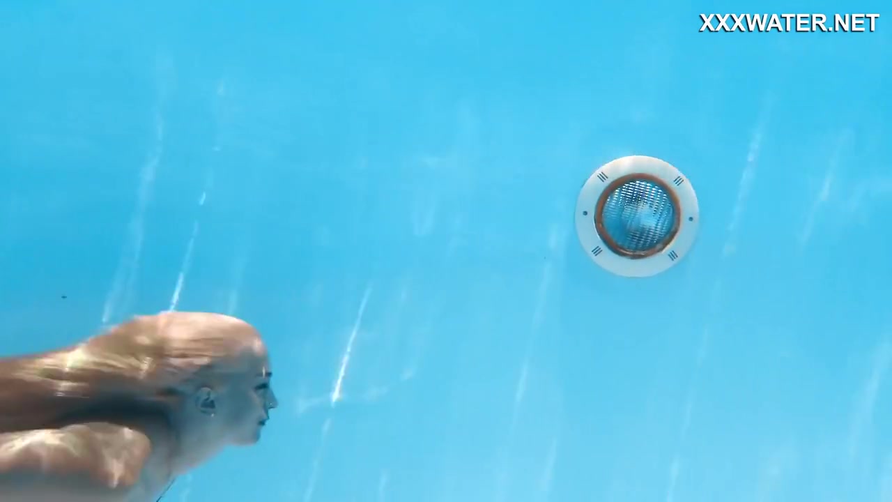 Her Body Cutting Through The Shimmering Water Of The Pool