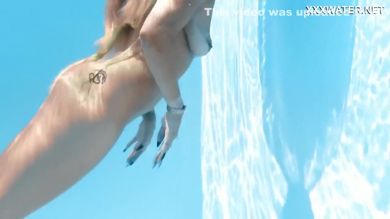 Her Body Cutting Through The Shimmering Water Of The Pool