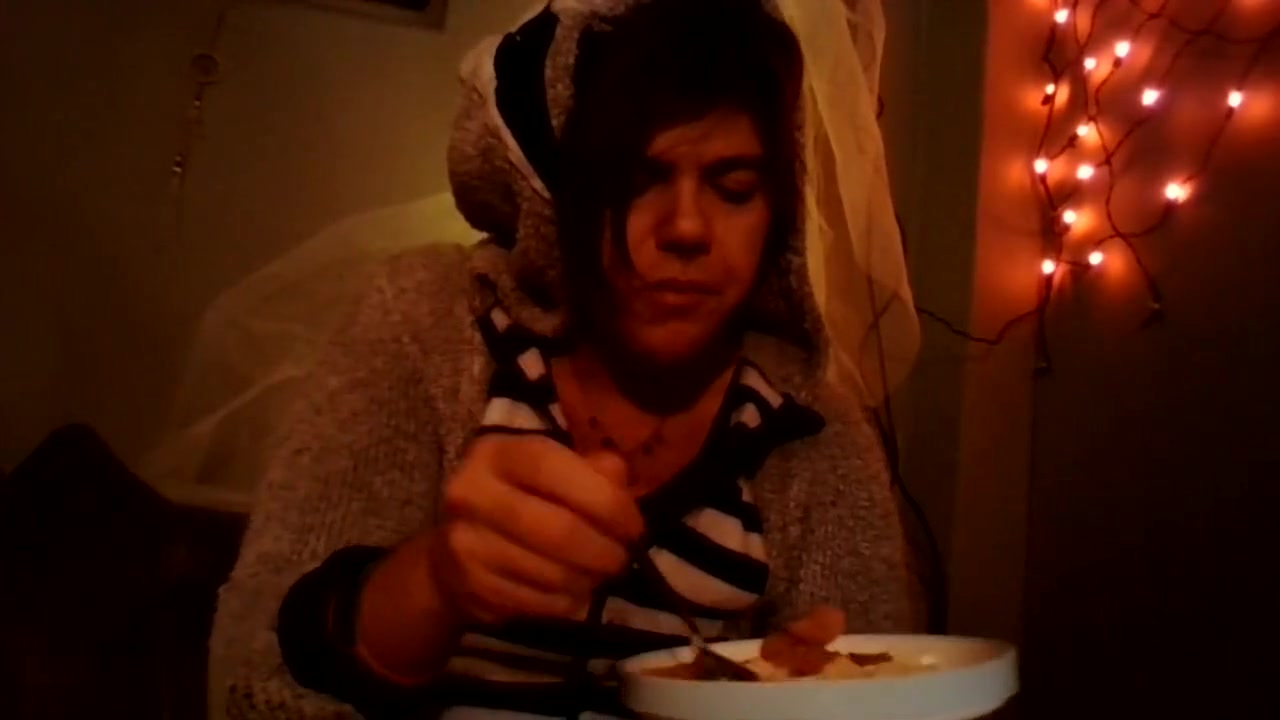 FtM little eating fish sticks in a onesie