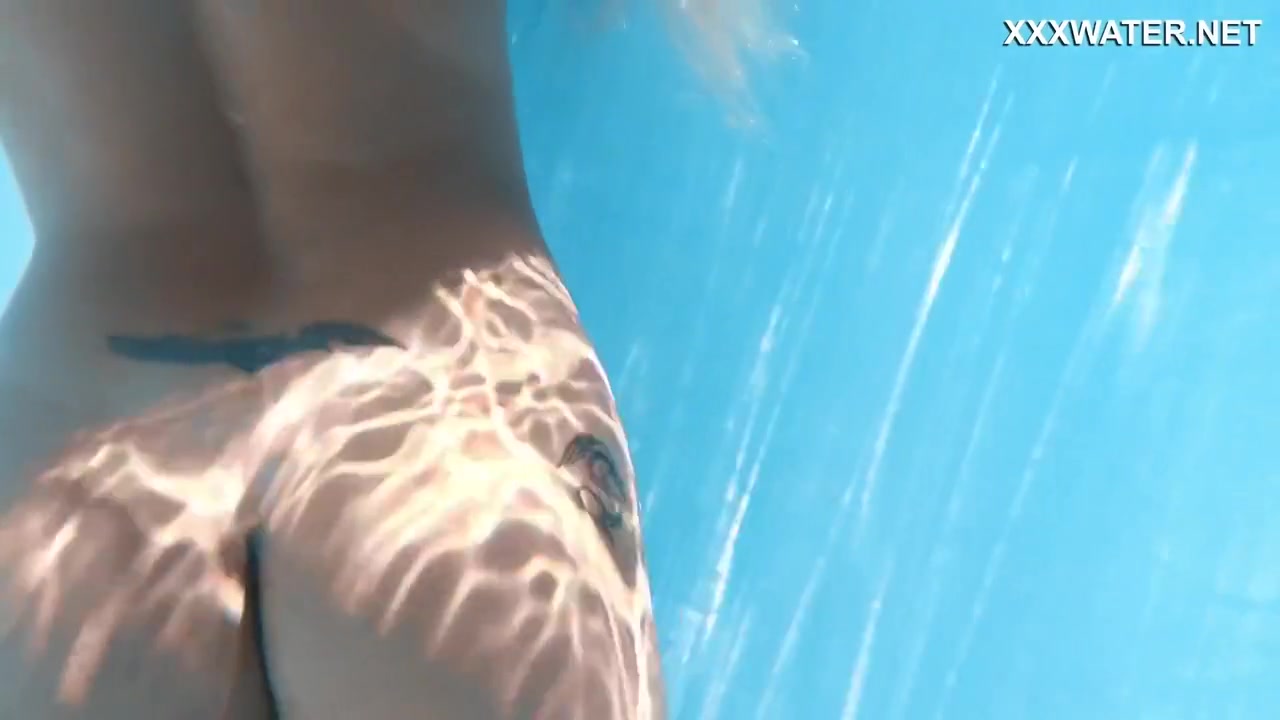 Her Body Cutting Through The Shimmering Water Of The Pool