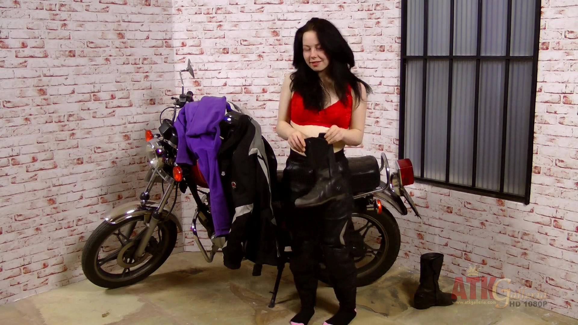 Lizzie does an extensive strip-tease by her big motorcycle