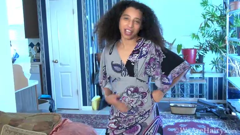 Divine strips naked by her brown couch