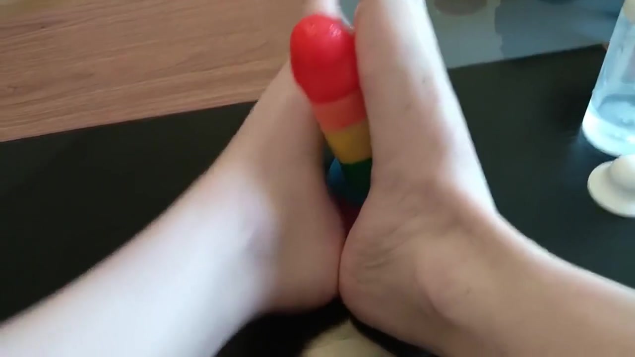 Femboy crossdresser gives rainbow dildo a footjob