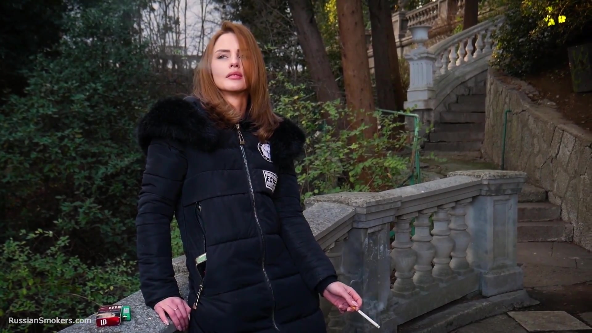 Absolutely Stunning Lady Is Smoking Two Long Cigarettes In The Park