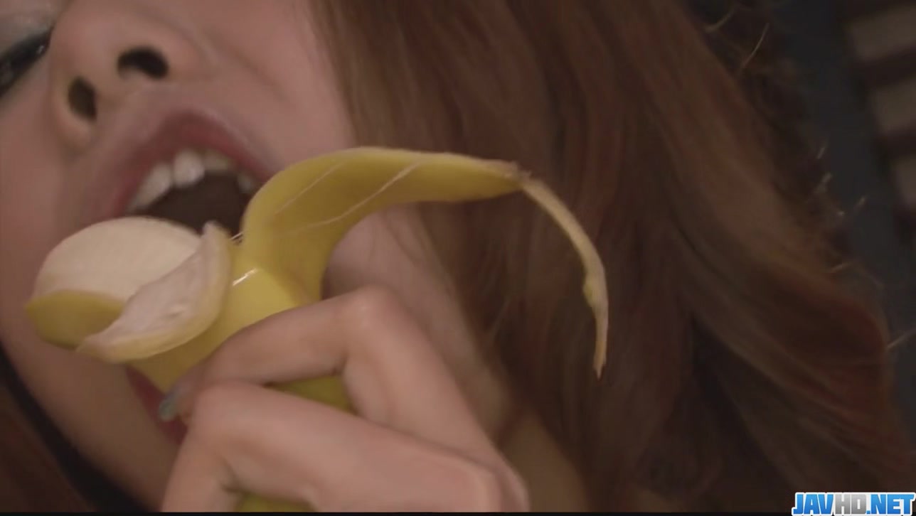 Hot and sexy redhead playing with a hard banana in the kitchen