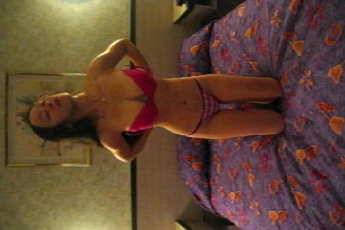 Sexy Asian babe stripping in front of a camera