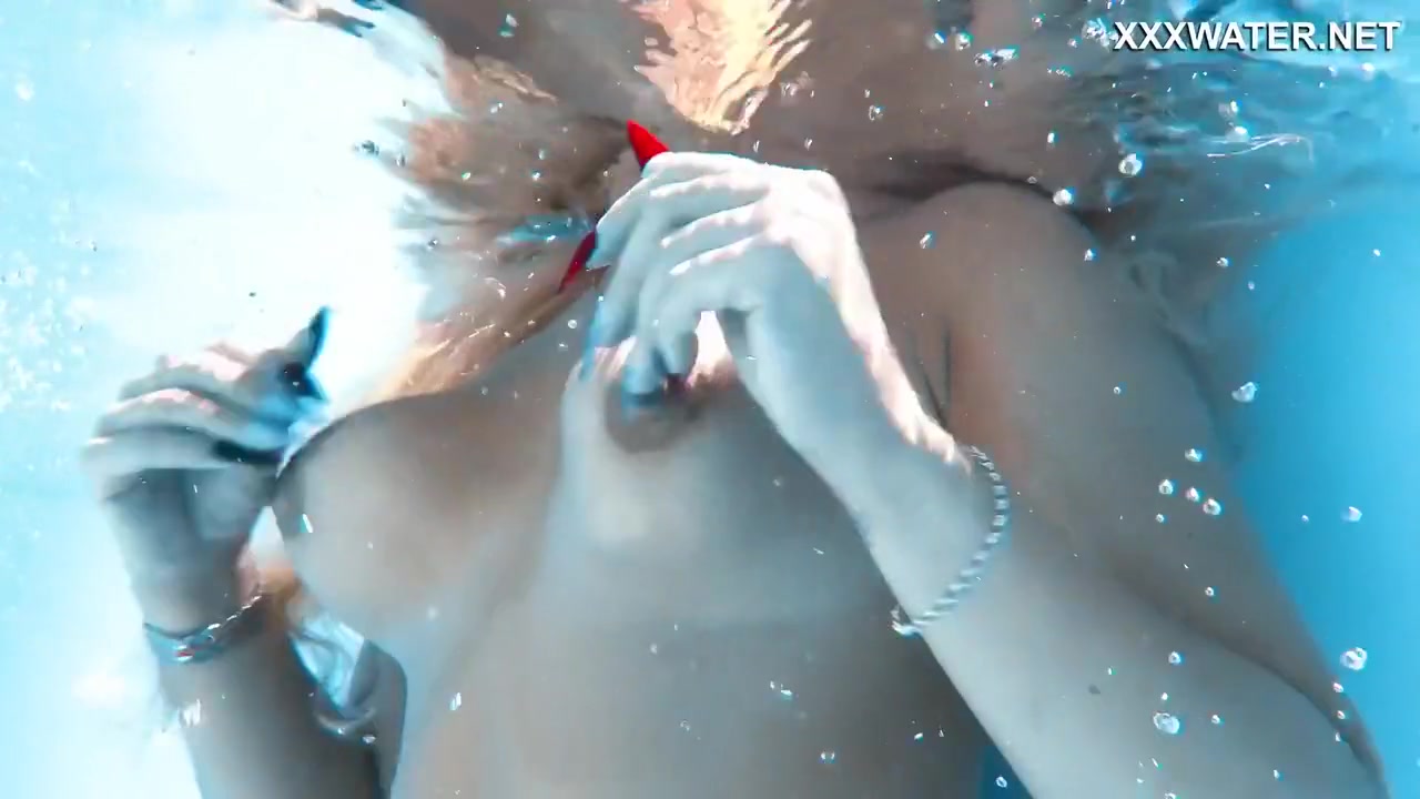 Her Body Cutting Through The Shimmering Water Of The Pool