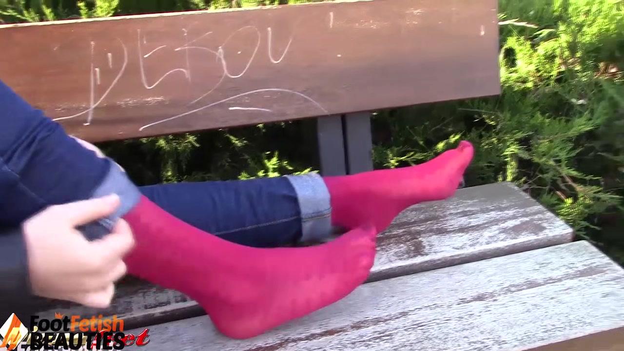 Barefoot brunette takes off nylons, shows feet in a park