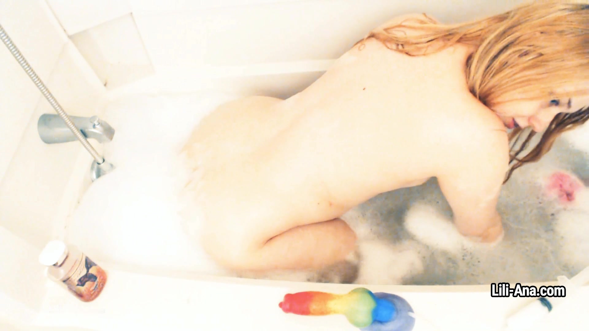 Lili Ana plays with suds in the bath and toys her hole