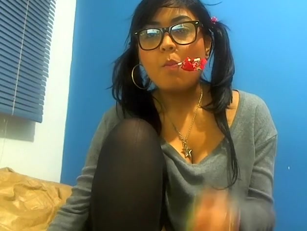 Pig-tailed adorable gal sucking a lollipop and showing her cleavage