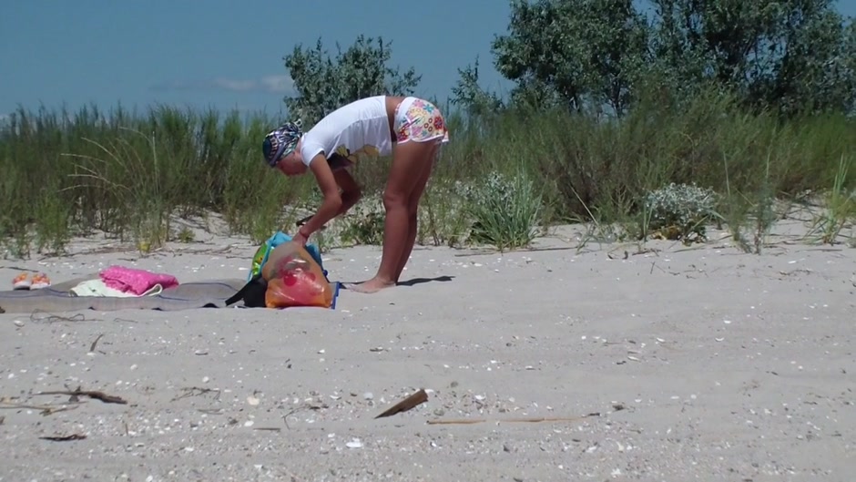 A couple of nudism lovers hardly pairing off on the sand