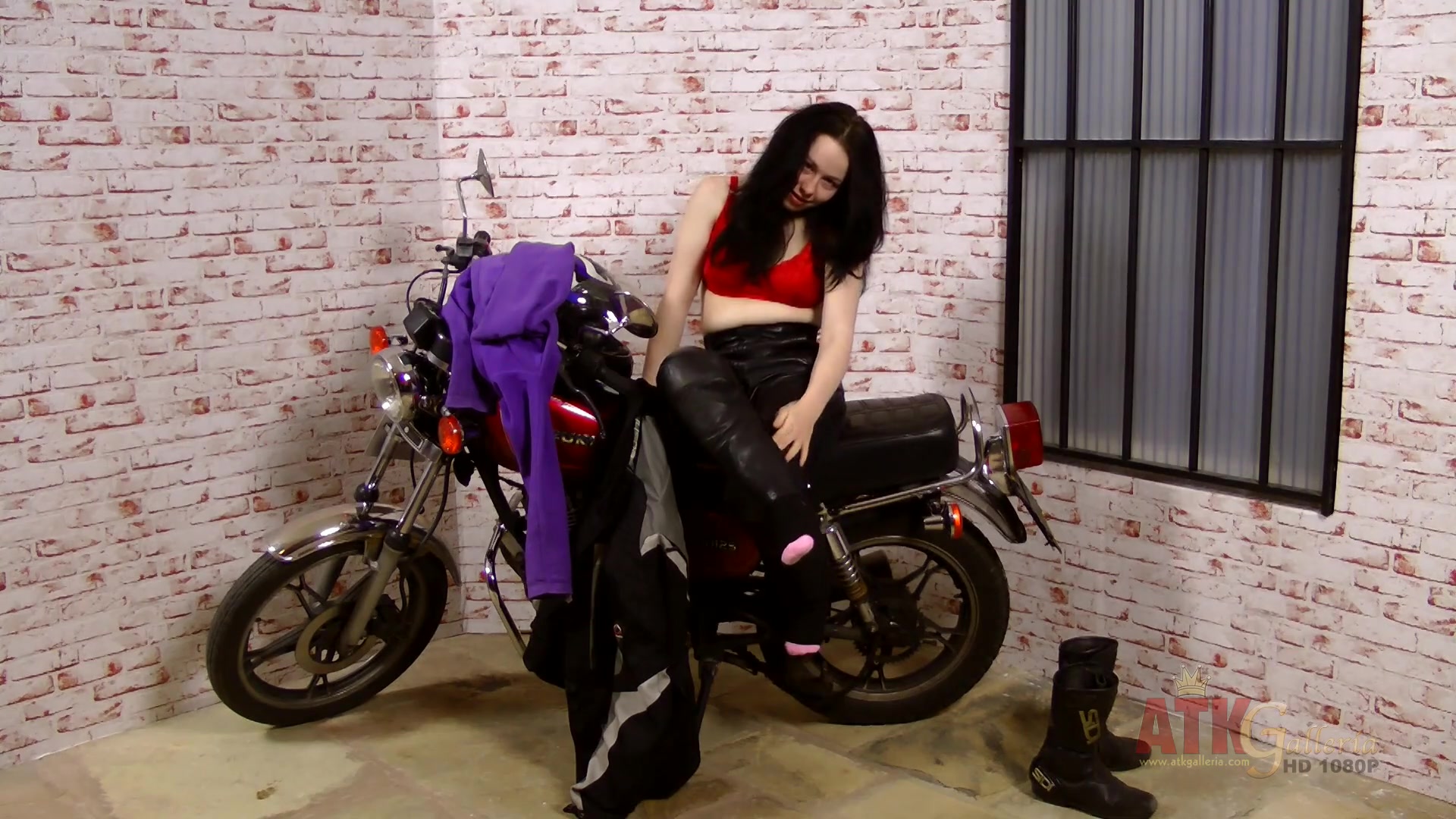 Lizzie does an extensive strip-tease by her big motorcycle