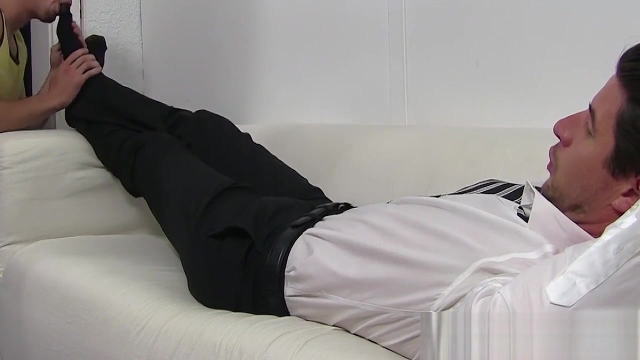 Handsome guy in a suit enjoys feet massage and toe sucking