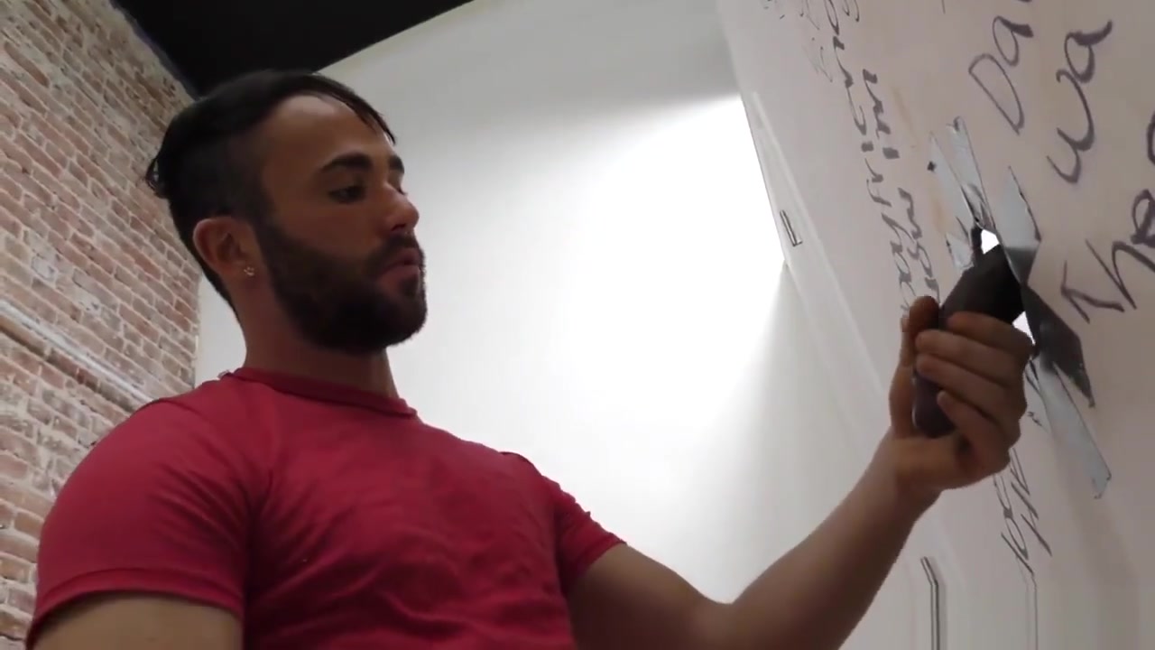 Bearded guy sucking off a black cock at a gloryhole