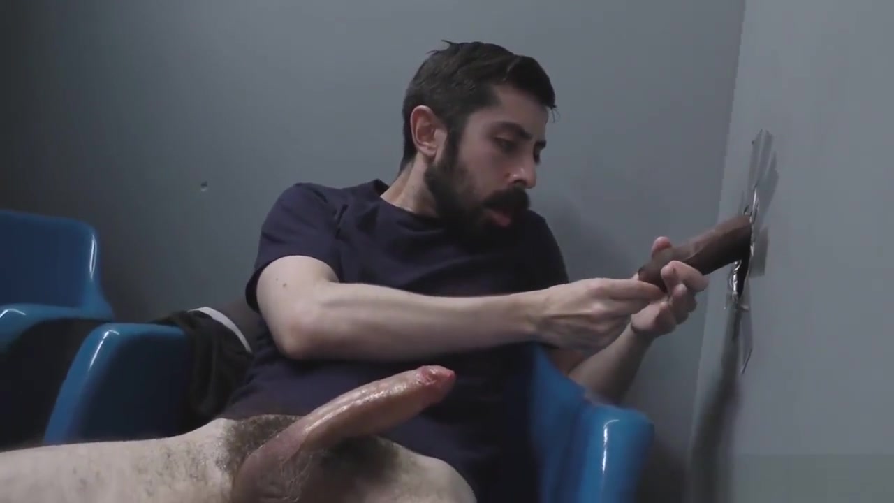 Bearded white man sucking and fucking a black cock at a gloryhole