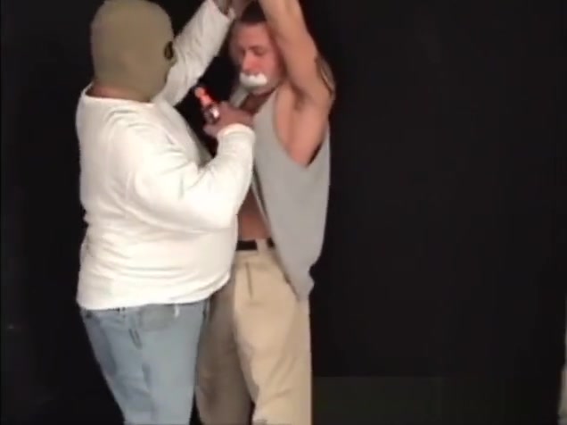 Handsome ex-military stud strung up by hs wrists gagged and stripped.
