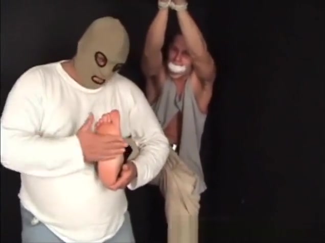 Handsome ex-military stud strung up by hs wrists gagged and stripped.