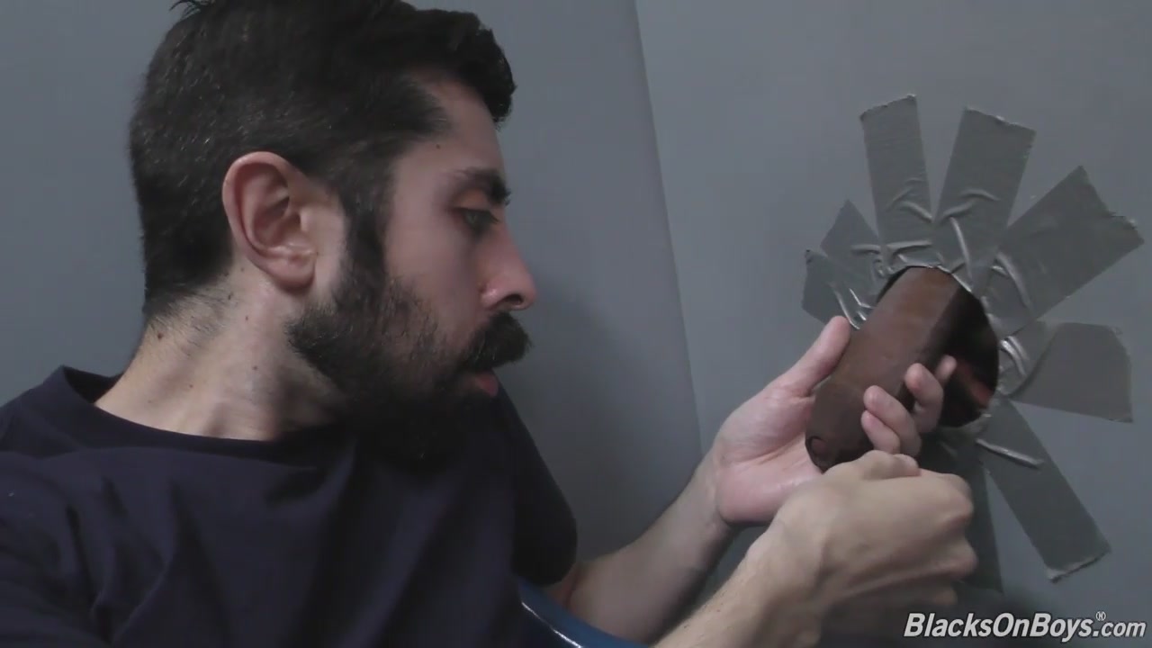 Bearded white man sucking and fucking a black cock at a gloryhole