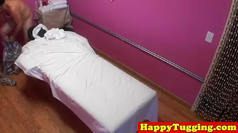 Busty asian masseuse tugging on client dick