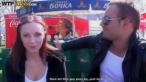 Redhead girl kneels and caresses two dicks
