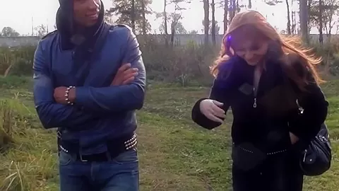 Busty redhead girl gives head to two guys in a park