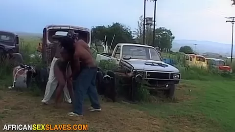 Masked Black Bitch Whipped and Banged in Public Junkyard by Two Cocks
