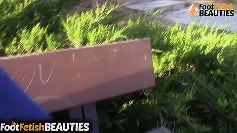 Barefoot redhead shows off her feet in public in the park