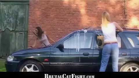 Two girls fight hard at a carwash