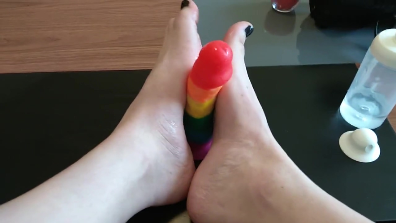 Femboy crossdresser gives rainbow dildo a footjob