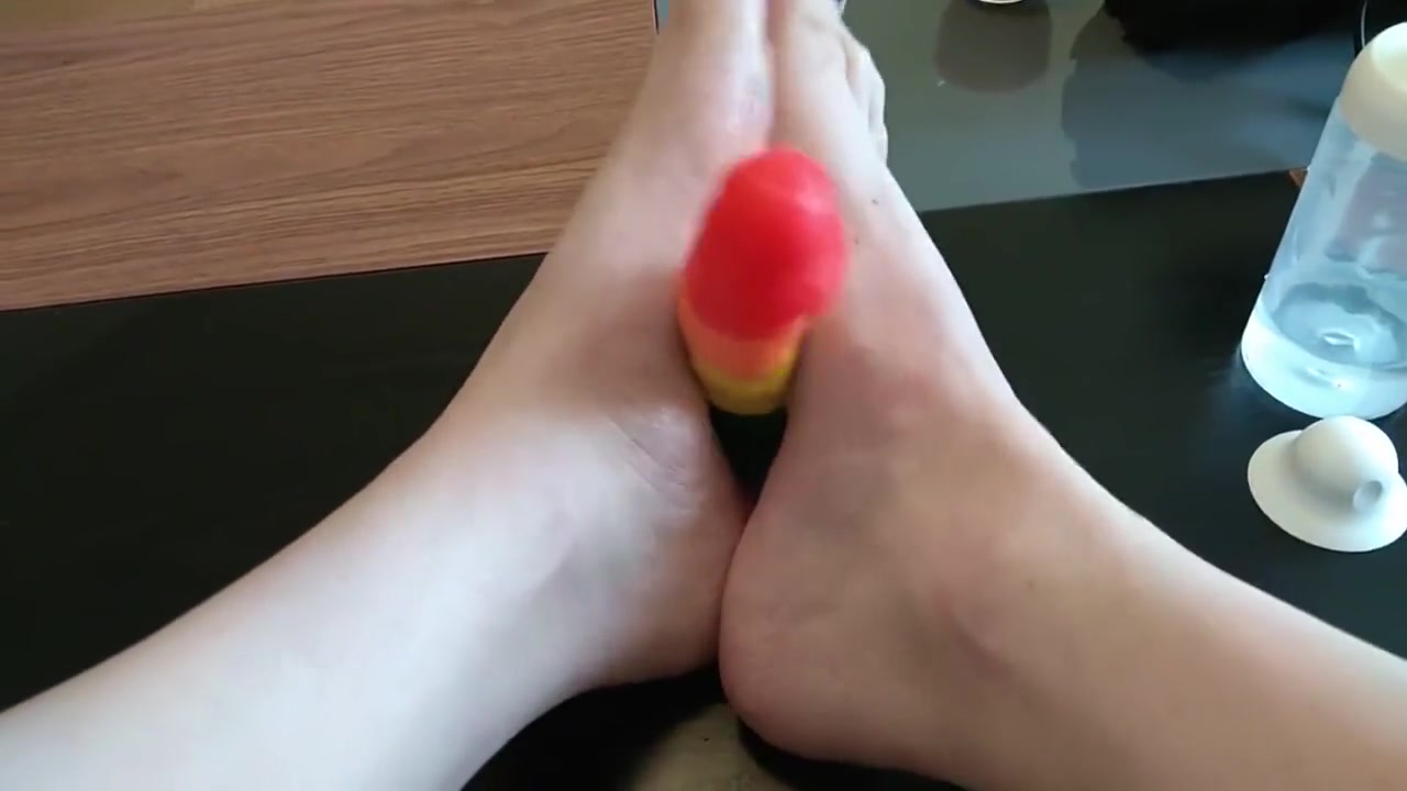 Femboy crossdresser gives rainbow dildo a footjob