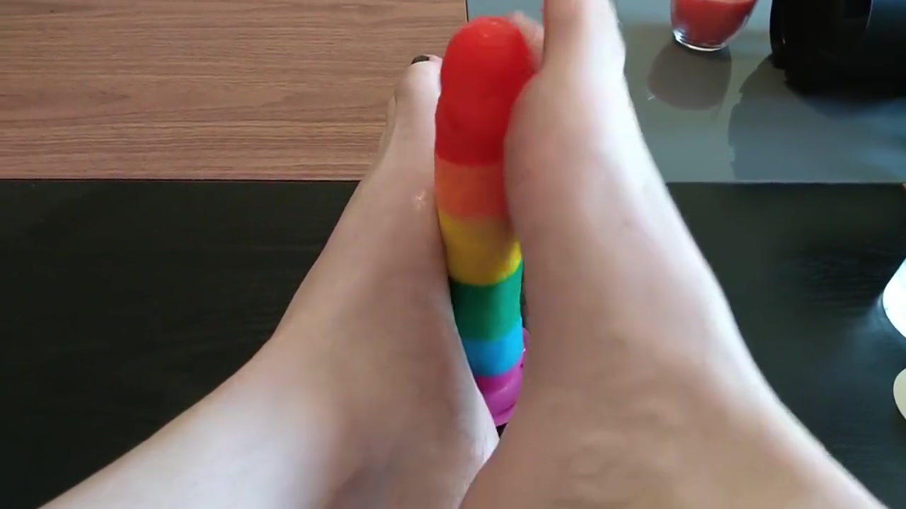 Femboy crossdresser gives rainbow dildo a footjob