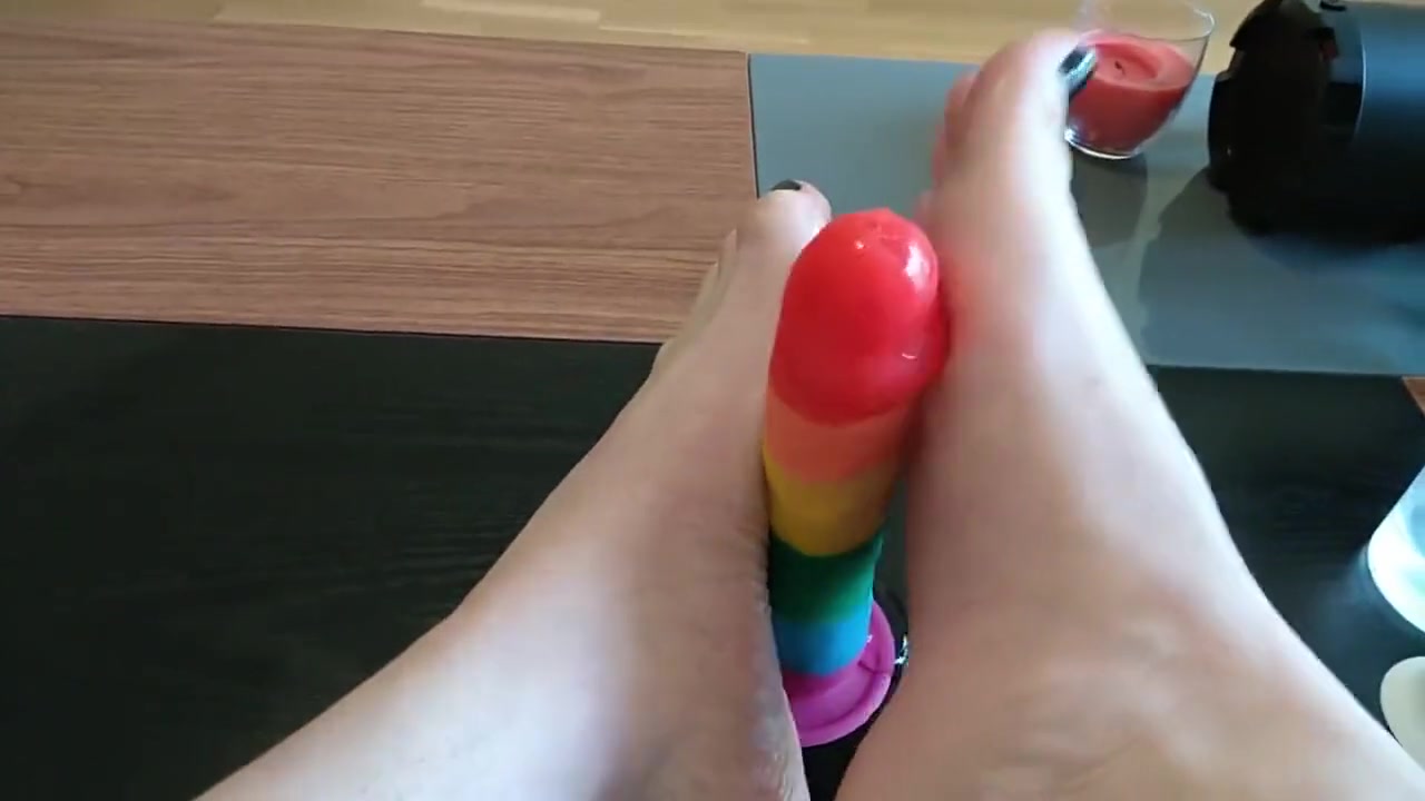 Femboy crossdresser gives rainbow dildo a footjob