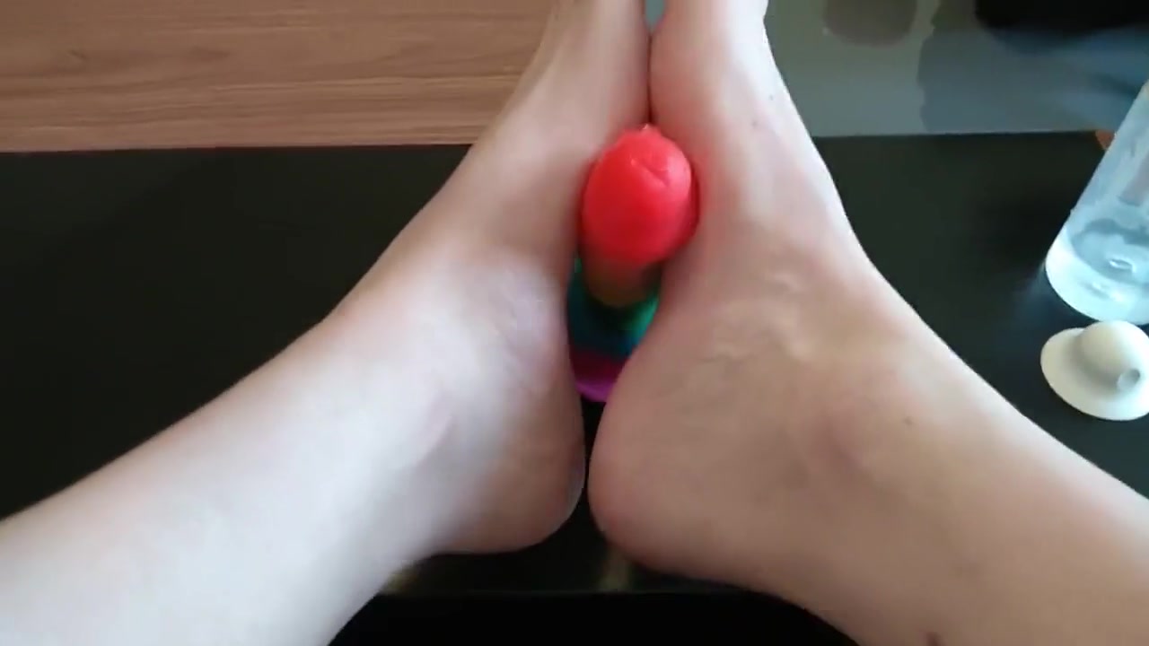 Femboy crossdresser gives rainbow dildo a footjob