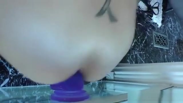 Stockinged tranny rides a dildo